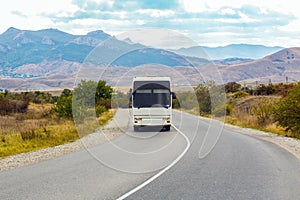 Bus is moving on a country road in a mountainous area