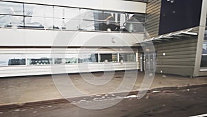 Bus with passengers passes by the buildings of Vnukovo airport. The buildings are fenced with a barbed fence