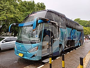 Modern Tour Bus Parked Beside The Sidewalk in Jakarta City