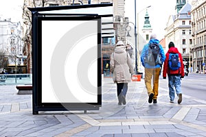 bus shelter with blank white ad billboard at busstop. blurred urban street setting with pedestrians