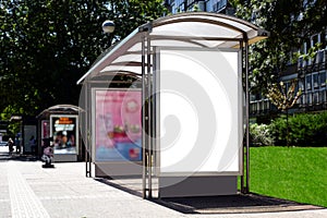 Bus shelter with empty white ad panel and lightbox.