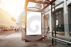 Bus stop billboard mockup. Sun light and street in background