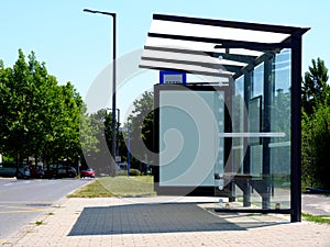 Clear glass design bus shelter with white advertising panel