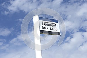 Bus stop sign sky background blue white clouds view below information public transport school old age pensioner travel free coach