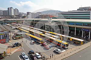 bus terminal with lines of buses and taxis, and the railway station in the background