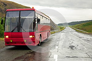 Bus traveling on asphalt road in rural mountain landscape