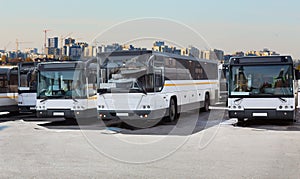 Buses in a parking lot amid the cityscape