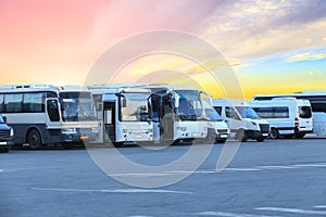 Buses in the parking lot of the bus station against the sky at sunset