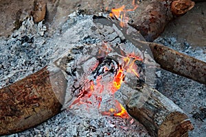 Campfire showing smoldering logs and red hot coals