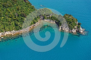 Bush clad hills reach down to the sea in New Zealand`s Abel Tasman National Park