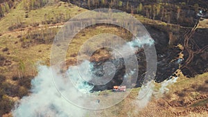 Bush Fire And Smoke. Drought Fire Engine, Truck On Firefighting Operation. Wild Open Fire Destroys Grass. 4K Aerial View