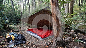 Bushcraft Tarp Shelter Camp. Wilderness Forest Bushcraft campsite. Survival Shelter