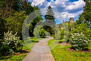 Bushes and trees along a path and the Cylburn Mansion at Cylburn Arboretum, Baltimore, Maryland.