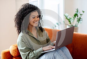 Bushy Woman Working On Laptop PC Sitting In Living Room