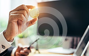 A busines man is holding a gold bitcoin photo