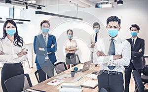 Busines people wearing face mask with presentation of business plan . Business meeting in modern office while pandemic of virus photo