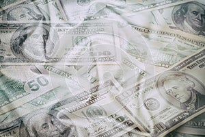 Business abstract background - banknotes of dollars close-up, scattered on wrinkled fabric