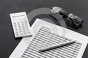 Business accounter work with taxes calculation and glasses on black office desk background