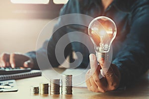 business accountin with saving money with hand holding lightbulb concept financial background photo