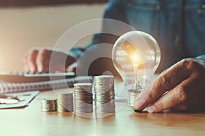 business accountin with saving money with hand holding lightbulb concept financial background