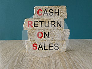 Business Acronym CROS as Cash Return On Sales words on brick blocks. Beautiful blue background