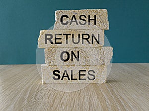Business Acronym CROS as Cash Return On Sales words on brick blocks. Beautiful blue background.
