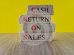 Business Acronym CROS as Cash Return On Sales words on brick blocks. Beautiful yellow background