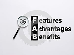 Business Acronym FAB - Feature Advantage Benefits. Magnifier magnifies the star symbols with the word FAB Features Advantages