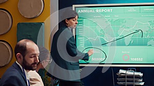 Business affiliates reviewing annual infographics reports in corporate briefing
