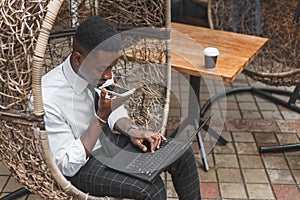 Business african american man holding smartphone, dictating voice message, recording audio, using voice mic. People