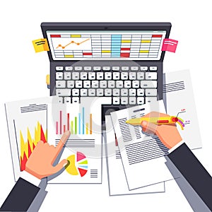 Business analyst or auditor working on statistical data paper document