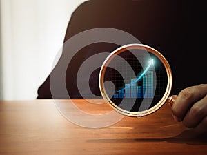 Business analytic chart, digital growth graph icon in round lens of gold magnifying glass.