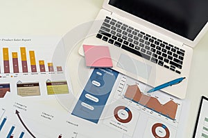 business analyzing investment charts with laptop pen on desk