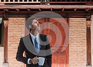 Business Asian man drinking coffee enjoying a coffee break and using ideas