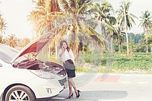 Business asian woman with a broken car calling for assistance.