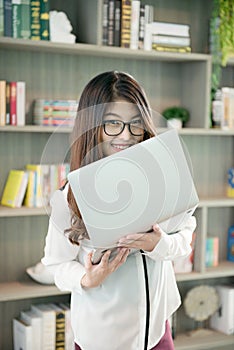 Business Asian woman holding a laptop in library