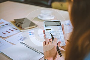Business asian woman sitting at a desk at an office By using the calculator to work. Business Concept Analysis and Planning