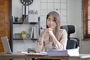 Business asian woman using calculator for do math finance on wooden desk in office, tax, accounting, financial concept.