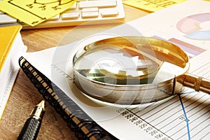 Business assessment and audit. Magnifying glass on a financial report.