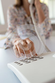 Business assistant dialing a telephone number