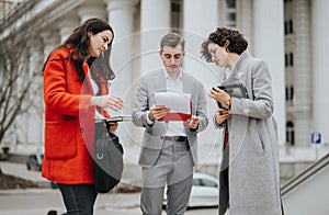 Business associates discussing project details outside office building
