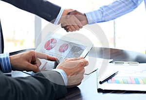 Business associates shaking hands in office