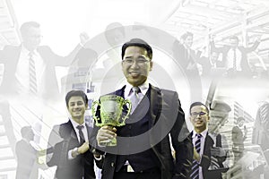 The business award , business team the leader holding golden trophy in hand with blur picture of the detail plan working