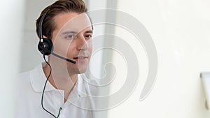 Business background of caucasian male customer service agent on telephone service to customers at helpdesk call center