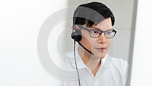 Business background of caucasian male customer service agent on telephone service to customers at helpdesk call center