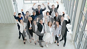 Business background of group of diverse business people, asian and caucasian, raise hands and fists up in concept of cheer up