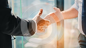 Business background of hand of businessman in suit going to having handshake with light flare