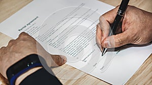 Business background of hand holding pen signing contract paper on desk