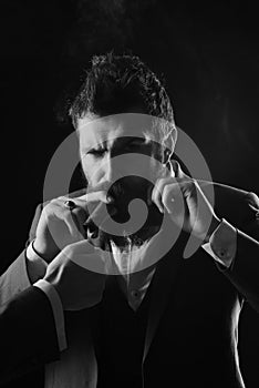 Business and bad habit concept. Man with beard holds cigar on black background.