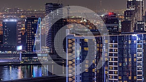 Business Bay Dubai skyscrapers with water canal aerial night timelapse.